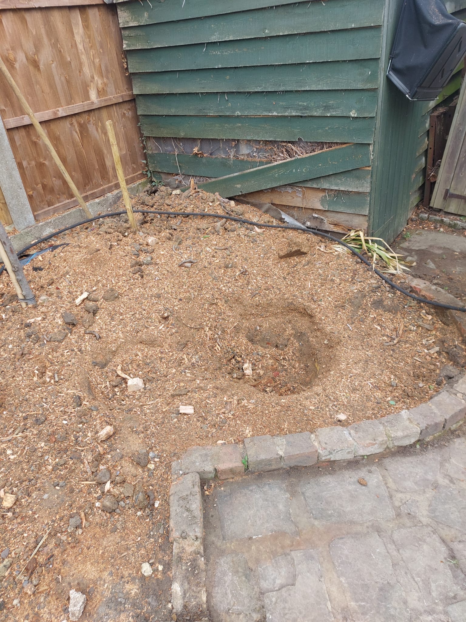 Area cleared after stump grinding beside shed and paved edging. Area cleared after stump grinding beside shed and paved edging.
